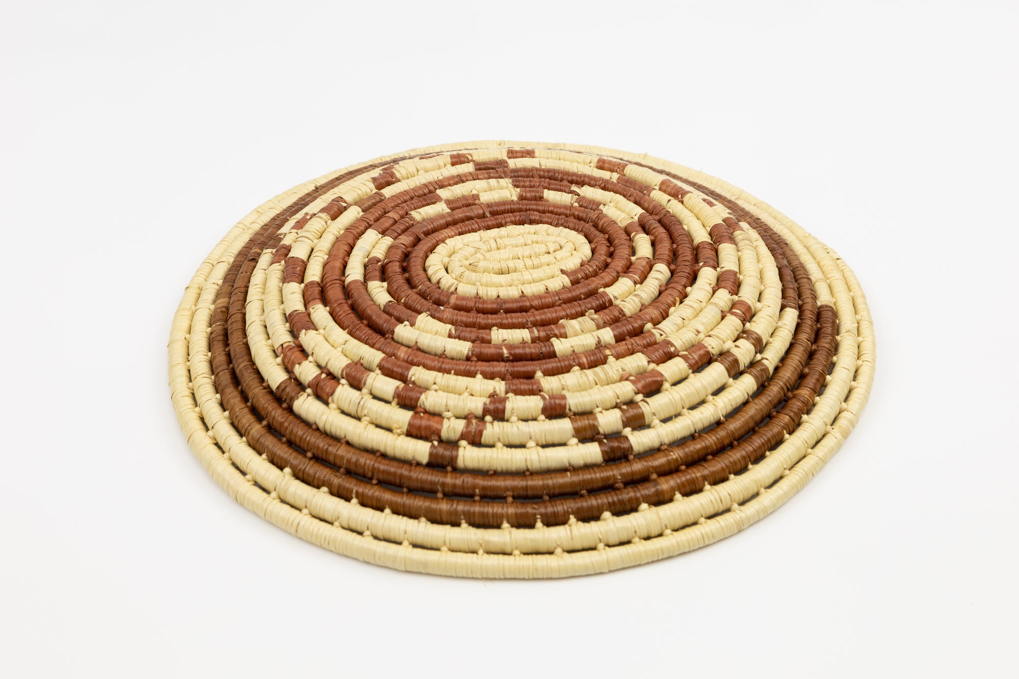 Hand woven plate basket from Panama. Brown and white colors. Wall decoration. Indigenous artists Panama.