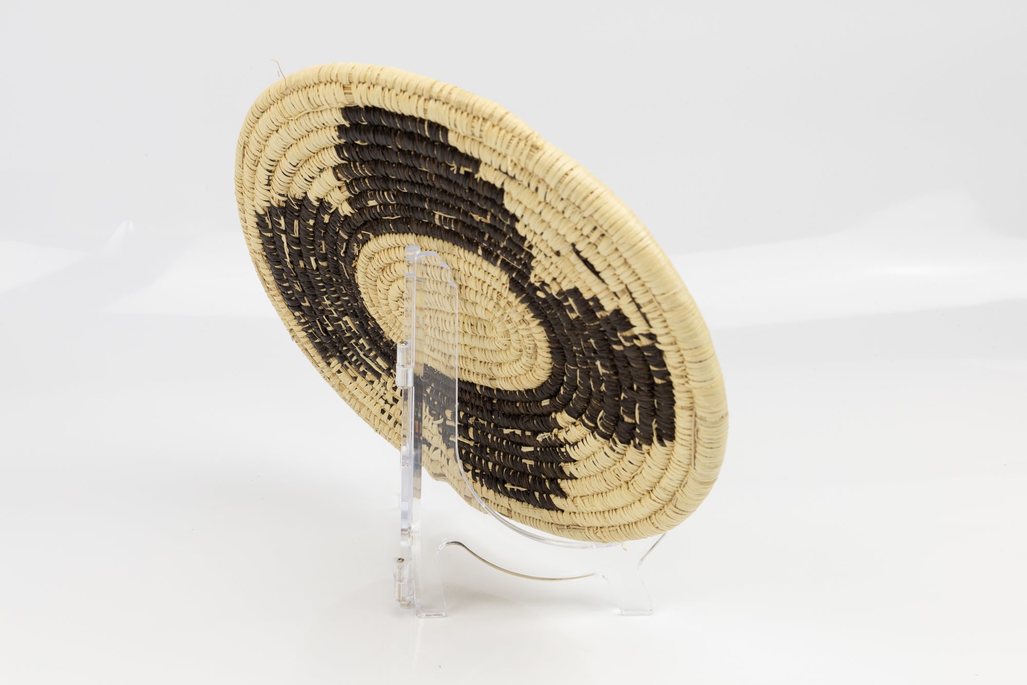 Hand woven plate basket. Black and white colors. 10" diameter and slightly oval in design. 