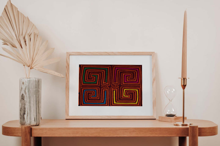 Hand stitched Guna mola from Guna Yala Panama, square spirals in orange on maroon