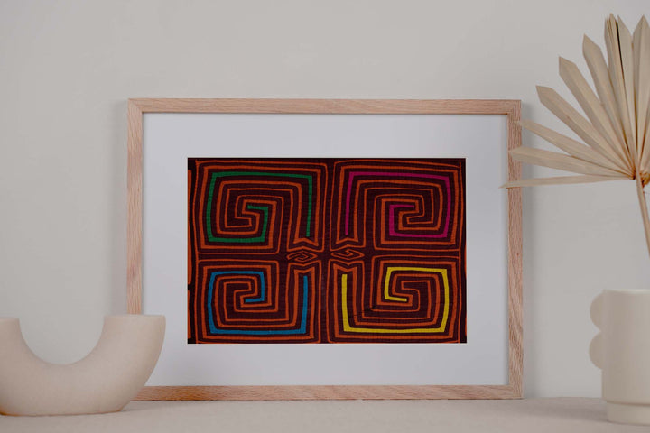 Hand stitched Guna mola from Guna Yala Panama, square spirals in orange on maroon