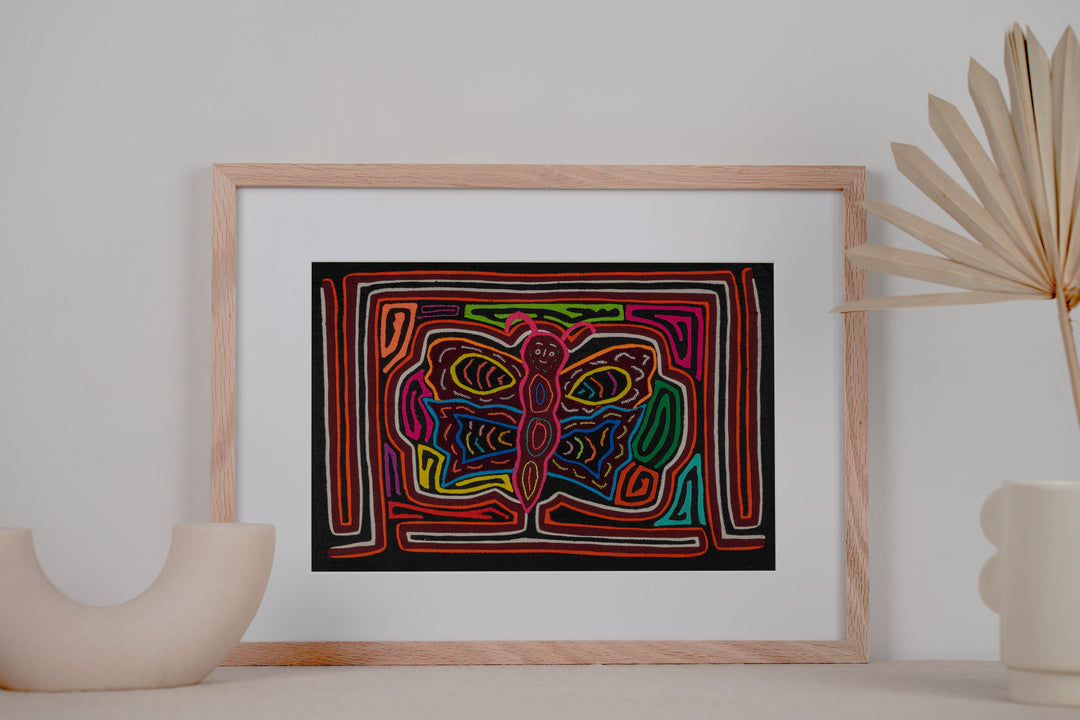 Panama mola panel, butterfly with pink antennae and a wide grin on black, hand stitched reverse applique