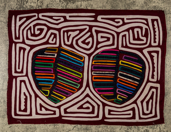 Panama mola panel, two striped fruit shapes in a white maze on maroon, hand stitched reverse applique