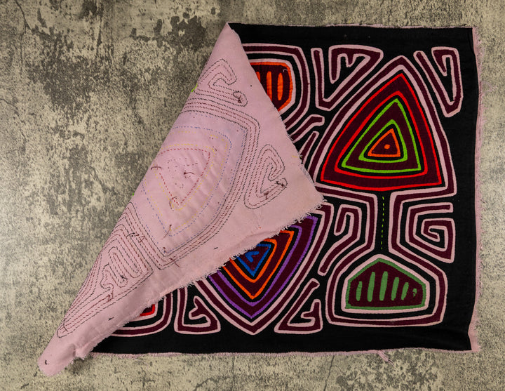 Hand stitched Guna mola from Guna Yala Panama, pink maze channels around the spade shapes