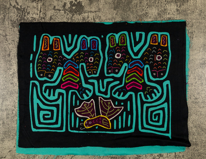 Panama mola panel, four heads with tall ears above a leafy bird on black, hand stitched reverse applique