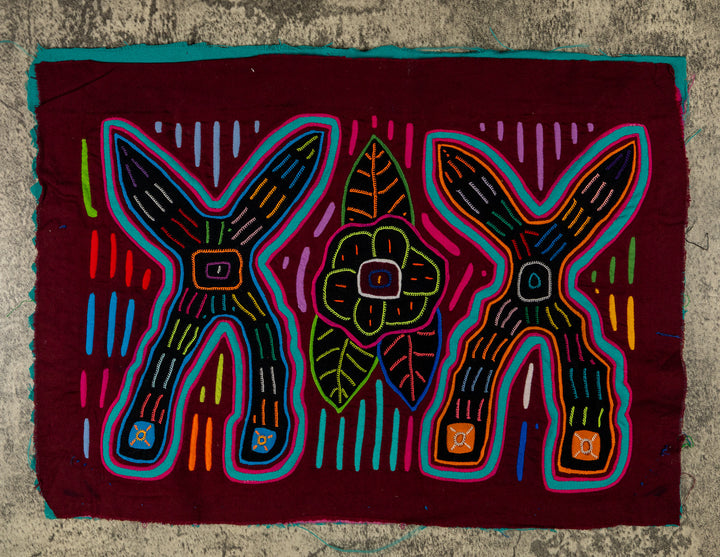 Panama mola panel, two big crossed shapes with a flower and leaves on maroon, hand stitched reverse applique