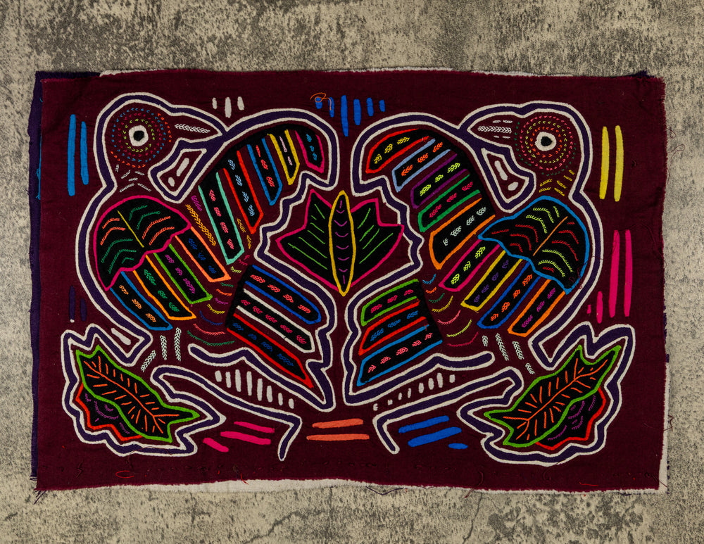 Panama mola panel, two big billed striped birds among leaves on maroon, hand stitched reverse applique