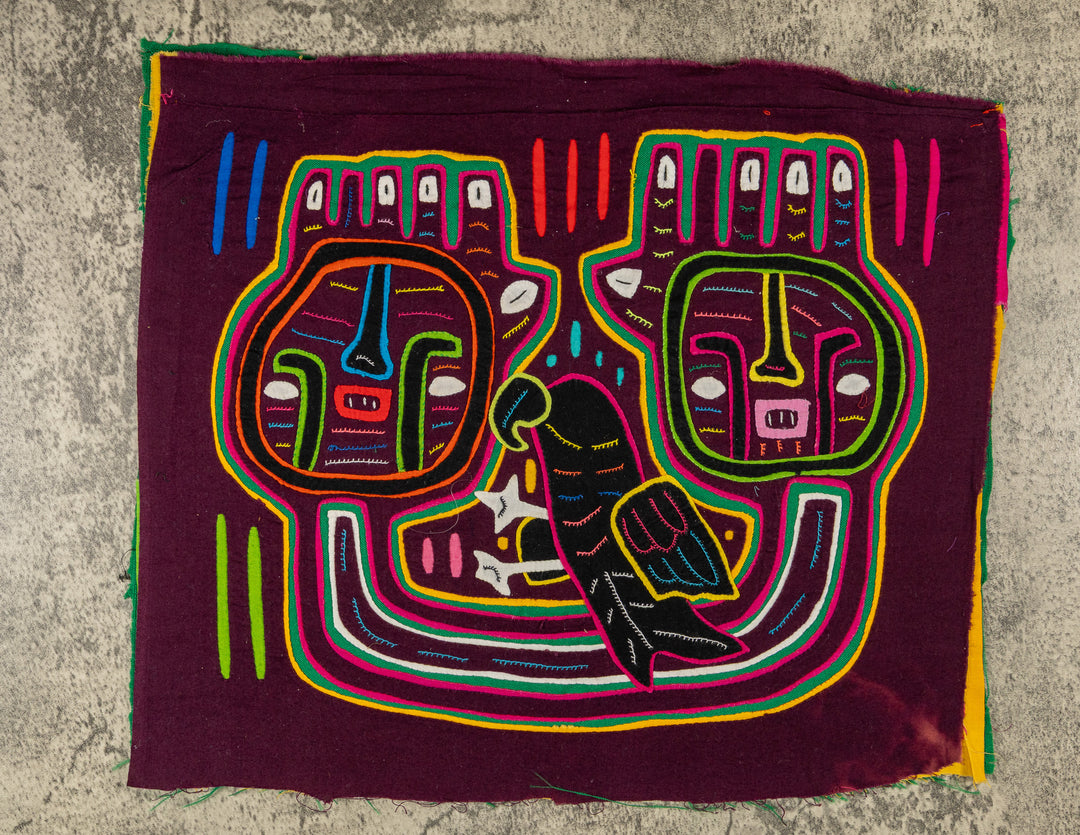 Panama mola panel, two big square faces and a dark parrot on maroon, hand stitched reverse applique