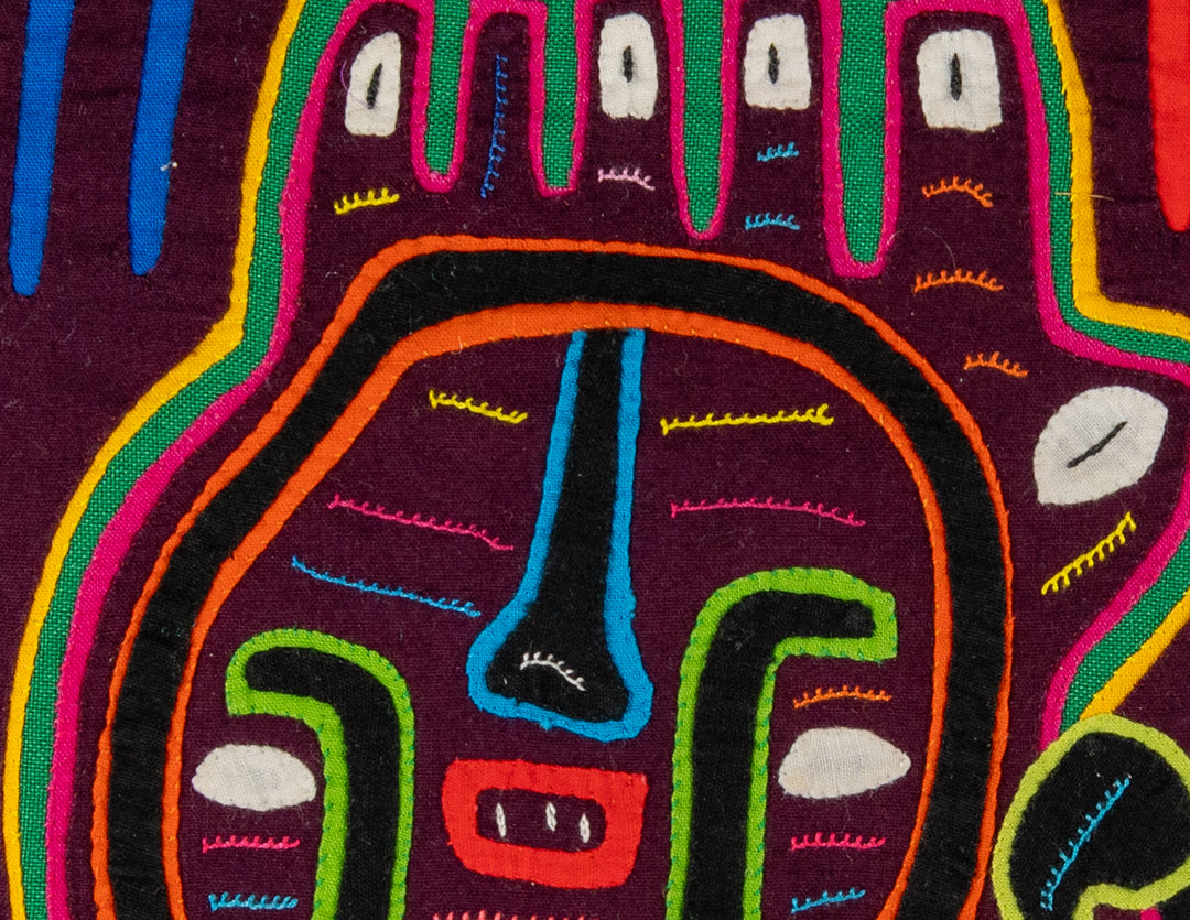 Faces with a parrot mola, hand stitched Guna panel from Panama, 14 by 12.5 inches