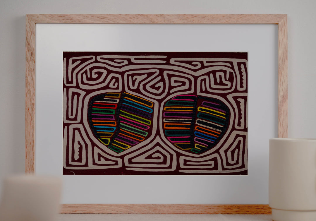 Panama mola panel, two striped fruit shapes in a white maze on maroon, hand stitched reverse applique