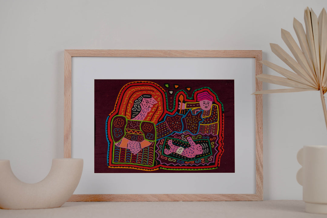 Panama mola panel, woman holding a baby with a torch bearer and a child on maroon, hand stitched reverse applique