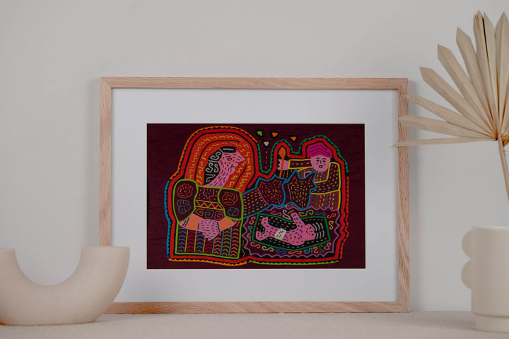 Panama mola panel, woman holding a baby with a torch bearer and a child on maroon, hand stitched reverse applique