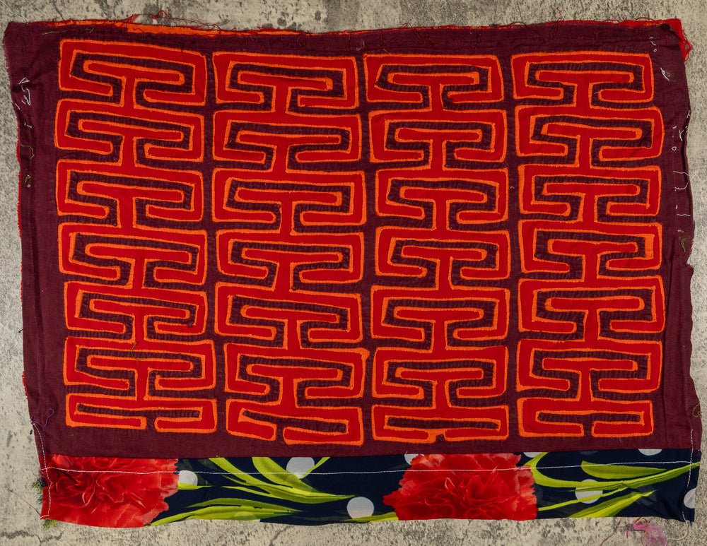 Panama mola panel, orange key pattern on red with a flower band at the lower edge, hand stitched reverse applique