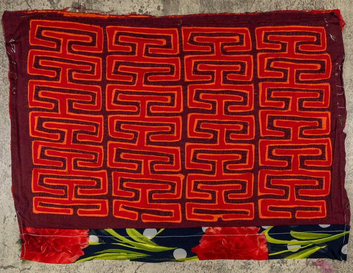 Panama mola panel, orange key pattern on red with a flower band at the lower edge, hand stitched reverse applique