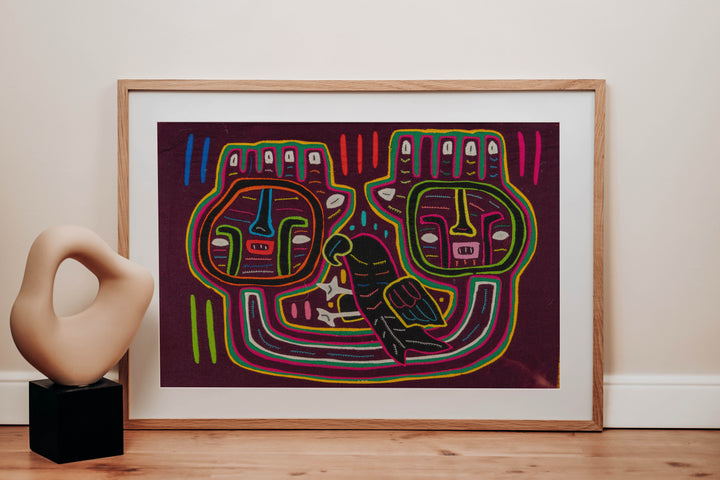 Panama mola panel, two big square faces and a dark parrot on maroon, hand stitched reverse applique