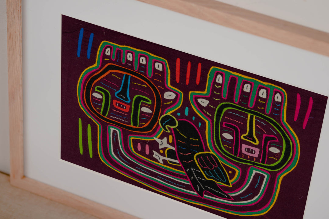 Hand stitched Guna mola from Guna Yala Panama, the parrot tucked beside the faces