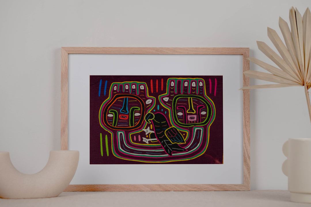 Panama mola panel, two big square faces and a dark parrot on maroon, hand stitched reverse applique