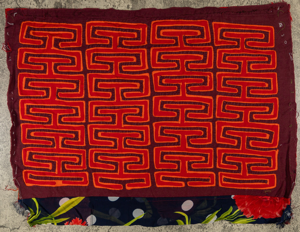 Panama mola panel, allover orange key pattern on red with a flowered strip, hand stitched reverse applique