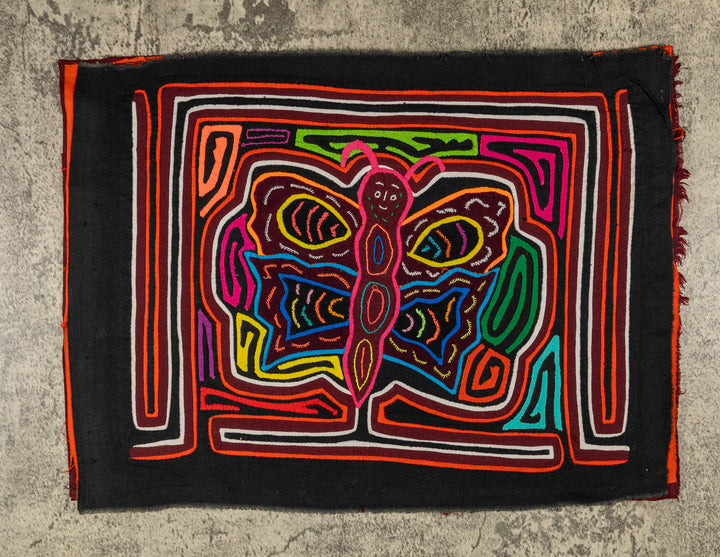 Panama mola panel, butterfly with pink antennae and a wide grin on black, hand stitched reverse applique