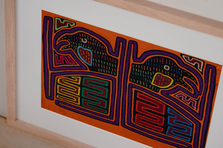 Hand stitched Guna mola from Guna Yala Panama, purple outlines on the frames and the birds