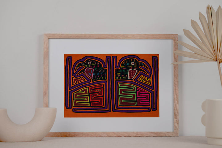 Panama mola panel, pair of hook billed birds in a framed cage on orange, hand stitched reverse applique