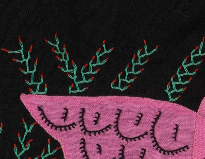 Hand stitched Guna molita from Guna Yala Panama, feathers cut through layered cotton on a black background