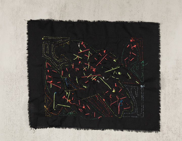 Hand stitched Guna molita from Guna Yala Panama, feathers cut through layered cotton on a black background