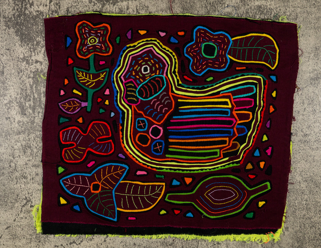 Panama mola panel, plump striped creature floating among flowers and leaves on maroon, hand stitched reverse applique