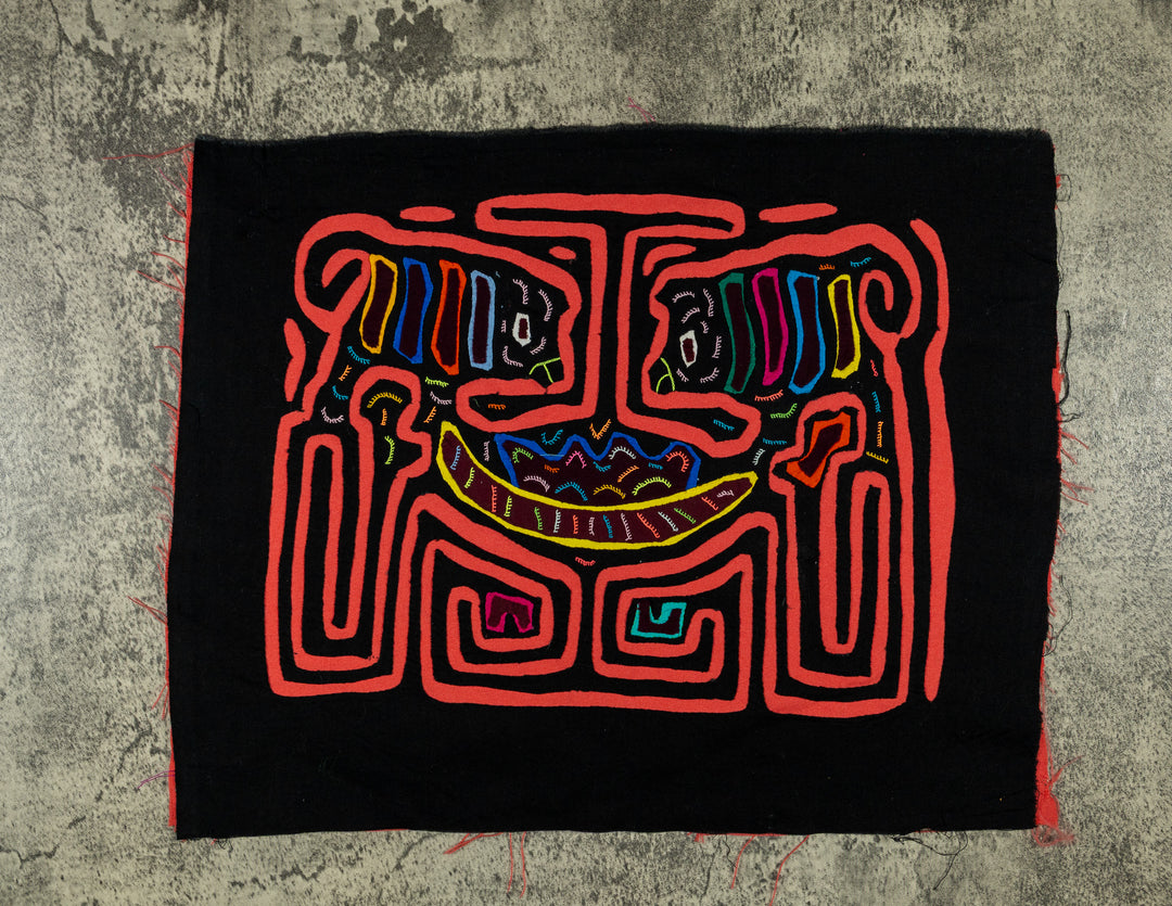 Panama mola panel, two small striped critters above a wide curve in coral orange on black, hand stitched reverse applique