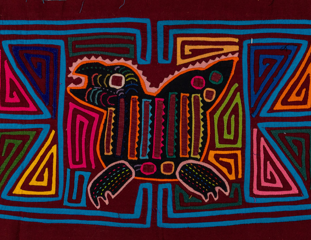 Jungle joker crouched in a maze mola, hand stitched Guna panel from Panama, 17 by 11 inches