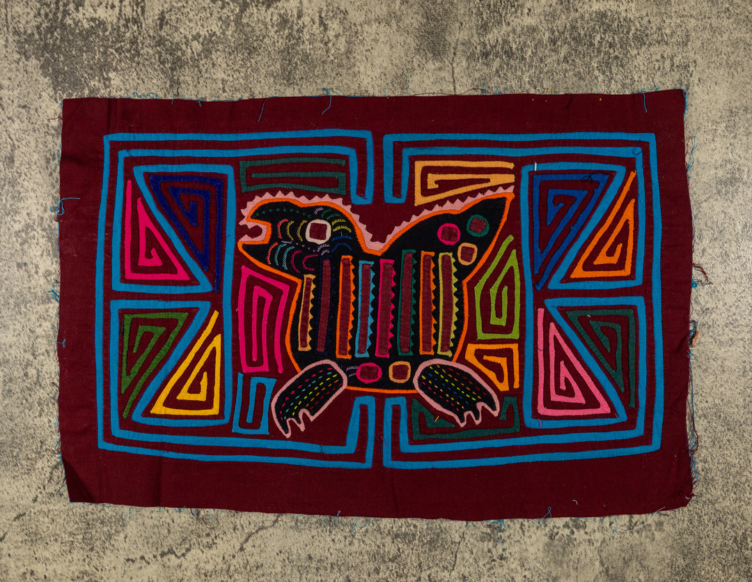 Panama mola panel, crested creature with a striped body and clawed feet in turquoise outline, hand stitched reverse applique