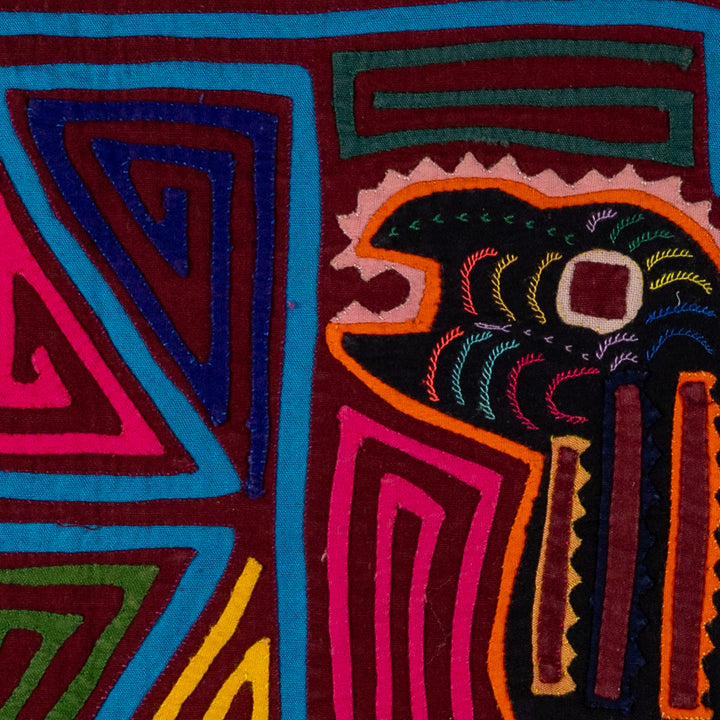 Jungle joker crouched in a maze mola, hand stitched Guna panel from Panama, 17 by 11 inches
