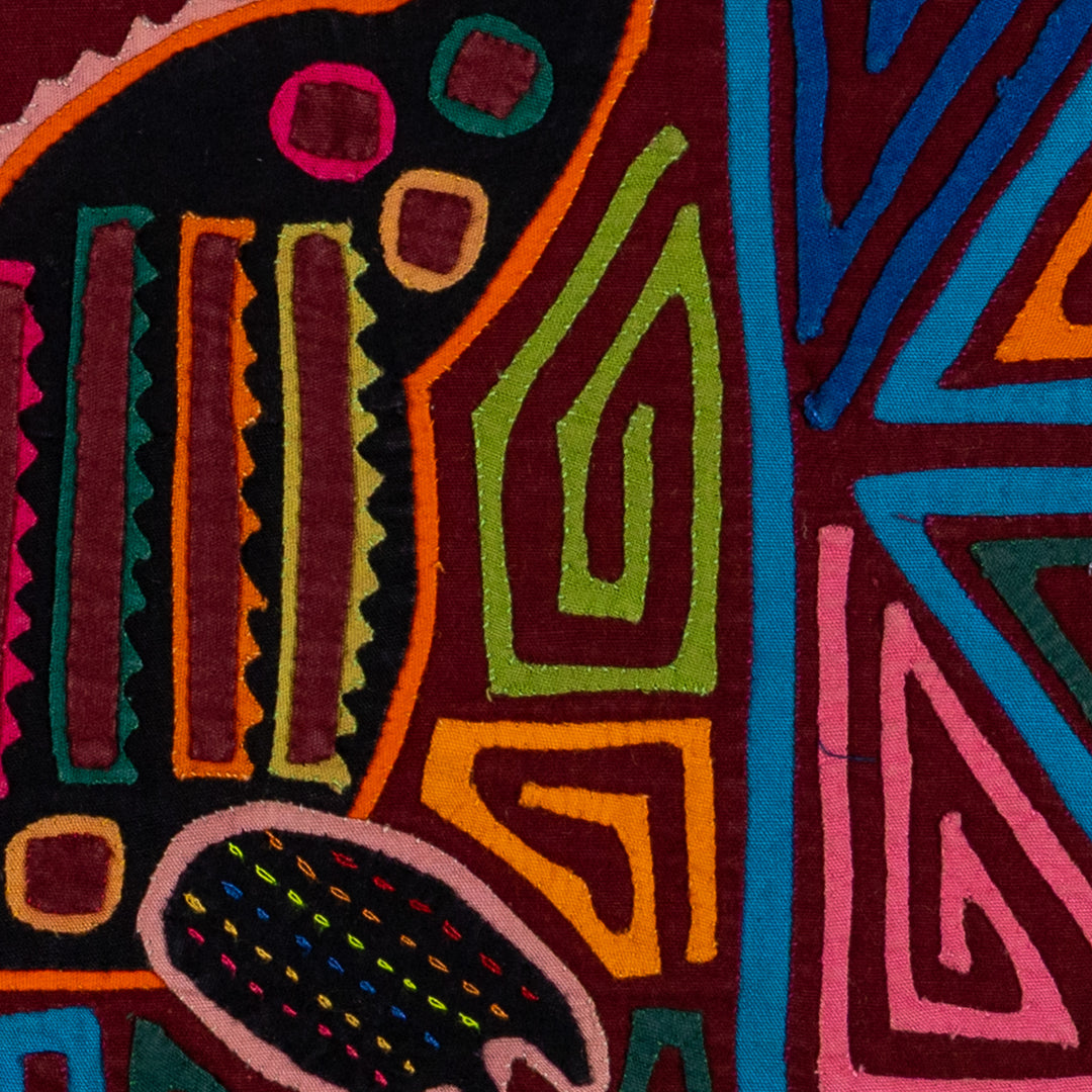 Jungle joker crouched in a maze mola, hand stitched Guna panel from Panama, 17 by 11 inches
