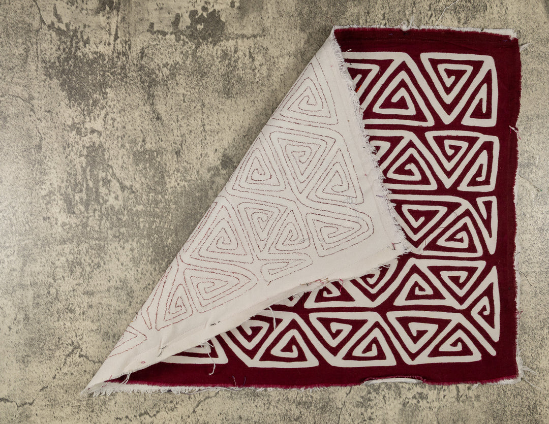 Hand stitched Guna mola from Guna Yala Panama, neat repeat of pointed spirals lined up row after row