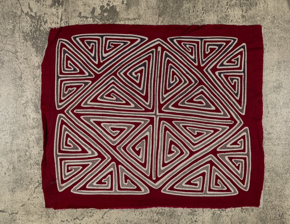 Panama mola panel, gray and white triangle spirals forming an X and diamond on maroon, hand stitched reverse applique