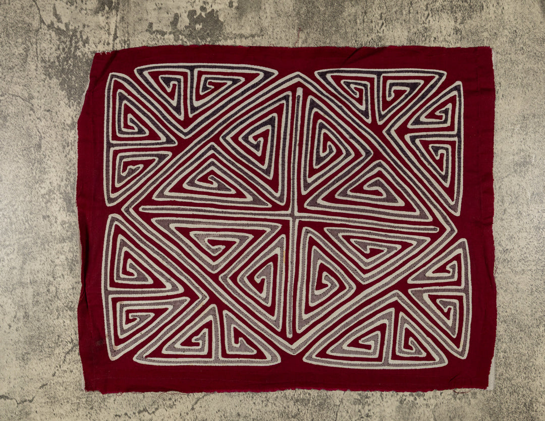 Panama mola panel, gray and white triangle spirals forming an X and diamond on maroon, hand stitched reverse applique