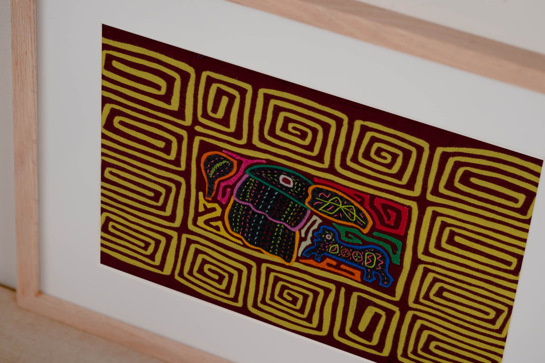 Hand stitched Guna mola from Guna Yala Panama, yellow spiral border running around the maroon center