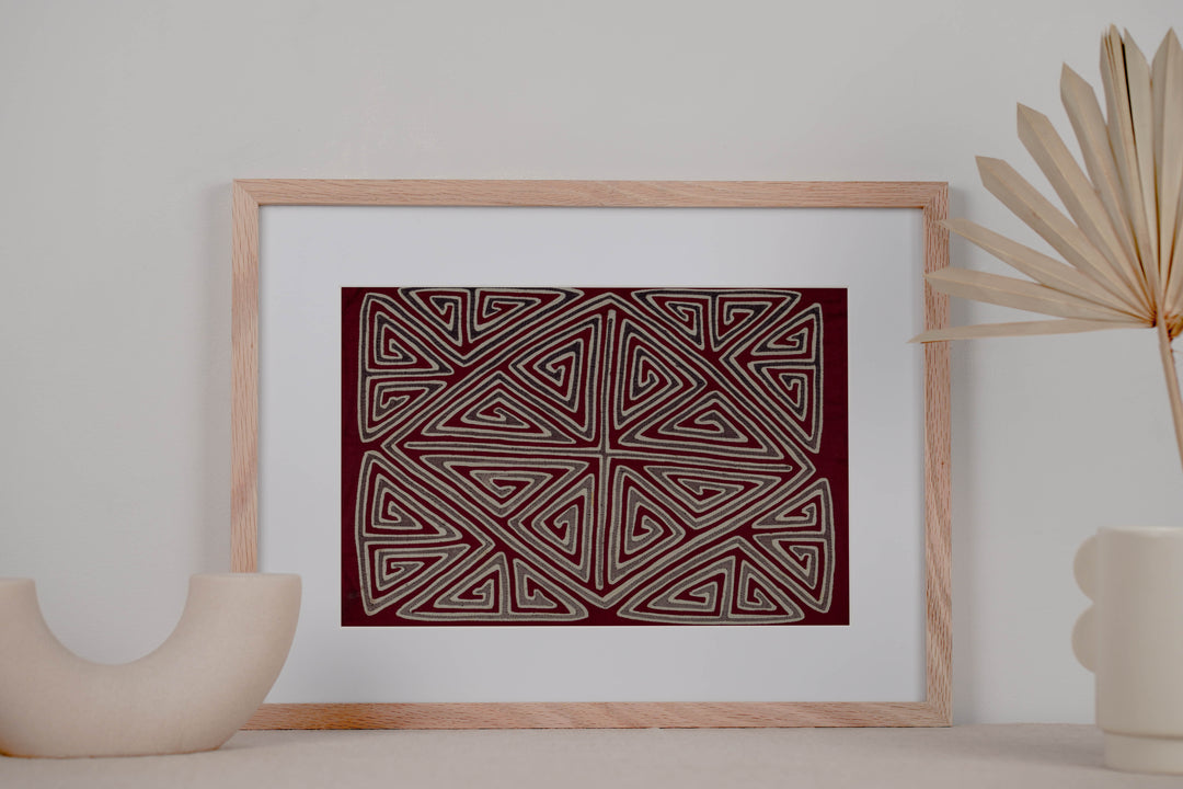 Panama mola panel, gray and white triangle spirals forming an X and diamond on maroon, hand stitched reverse applique