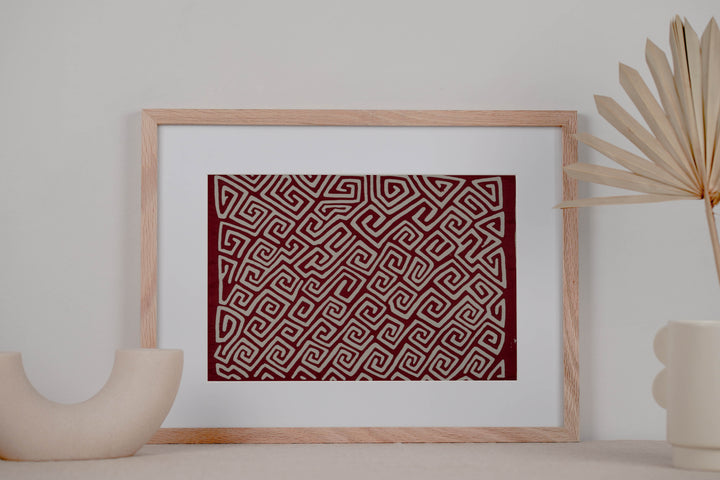 Panama mola panel, white key pattern running diagonally across maroon cloth, hand stitched reverse applique