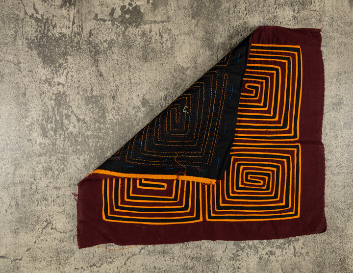 Hand stitched Guna mola from Guna Yala Panama, black accents between the spirals in a neat grid