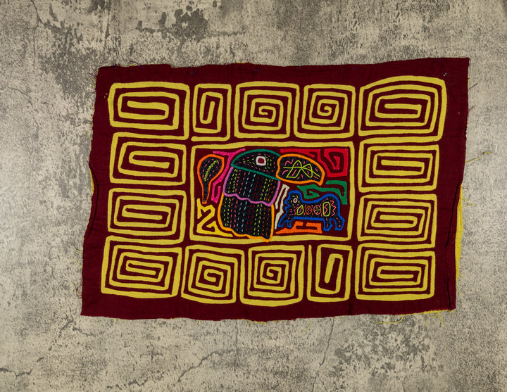 Panama mola panel, toucan beside a small blue critter inside a yellow spiral border, hand stitched reverse applique