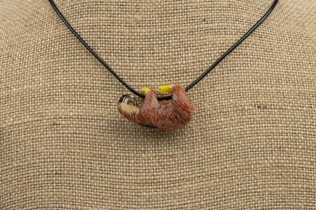 Sloth tagua pendant, orange with yellow markings, flat display