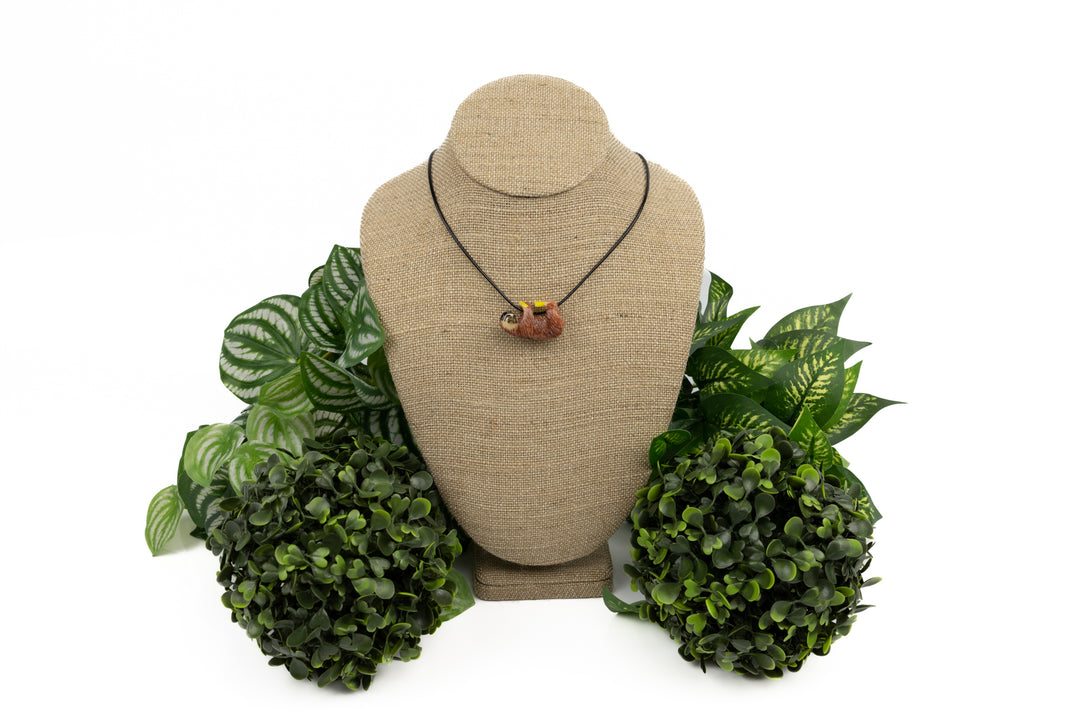 Sloth tagua necklace on green leaf