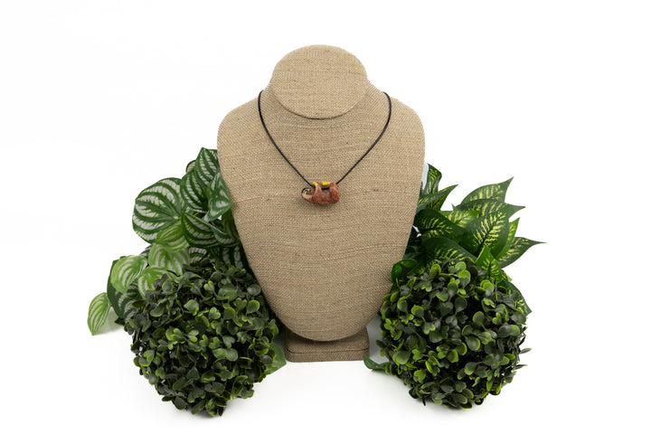 Sloth tagua necklace on green leaf