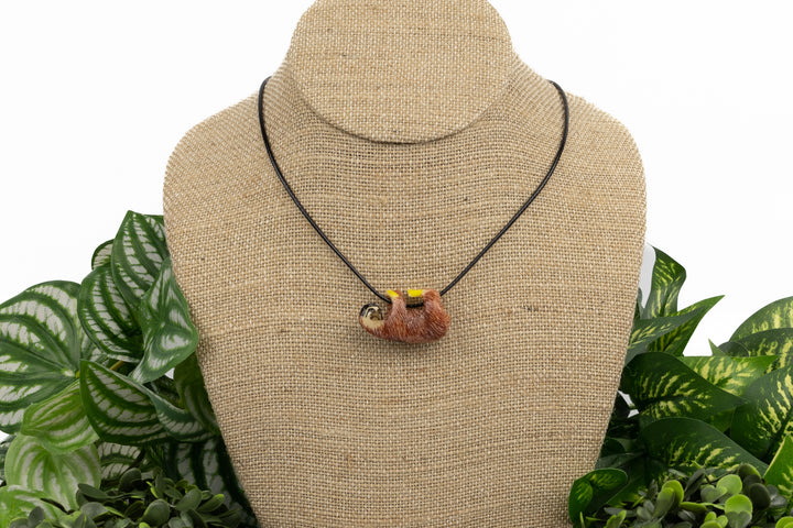 Grey sloth tagua necklace on display