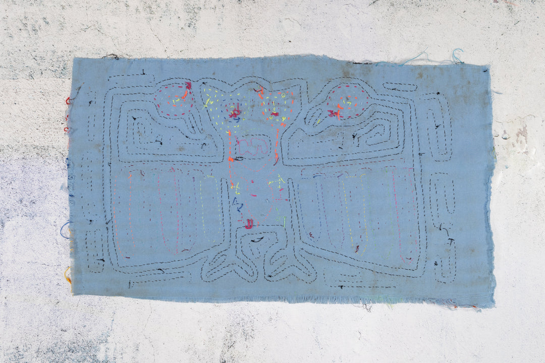 Hand stitched Guna mola from Guna Yala Panama, bird head advisors outlined in light blue